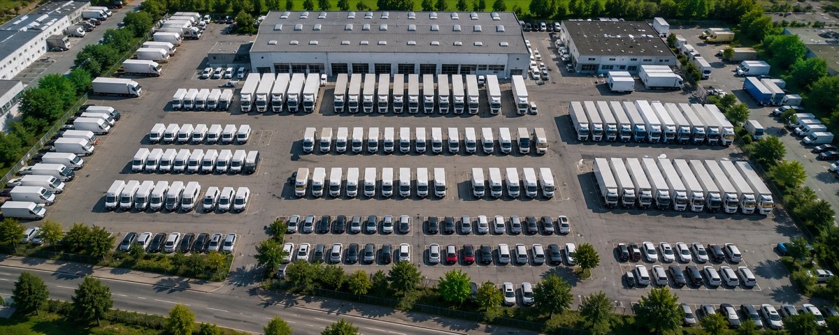 Firmenfuhrpark mit zahlreichen Transportern und LKW auf einem Betriebshof